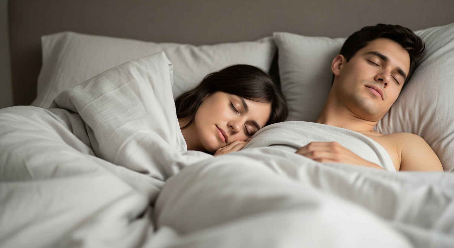 Pareja durmiendo en un colchón de dos plazas, de la marca sommistore, con ropa de cama blanca